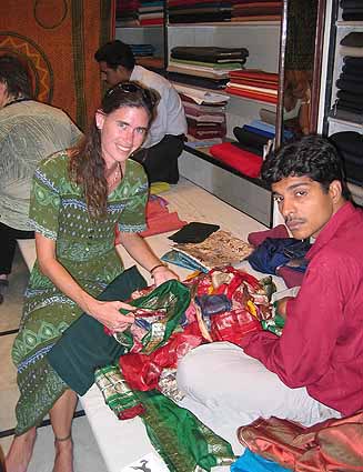 Kalasara chooses fabric to have clothes made.